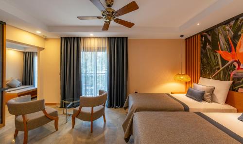 a hotel room with two beds and a window at Samara Hotel Bodrum Ultra All Inclusive in Torba