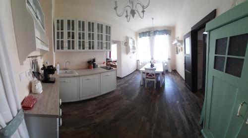 a kitchen with white cabinets and a wooden floor at Chalupa Jilemnice, celý prostorný dům jen pro vás s 5 ložnicemi v centru Jilemnice s uzavřenou zahradou in Jilemnice
