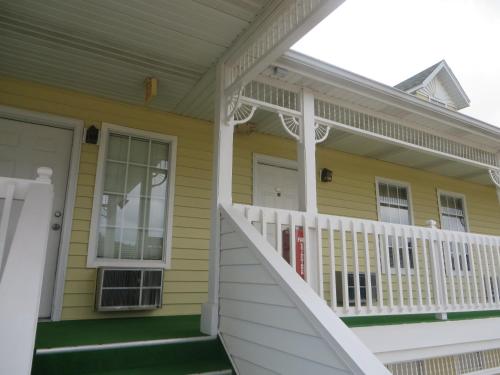 a front porch of a yellow house with a white railing at Honeysuckle Inn in Mountain View