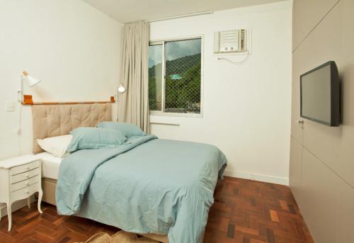 a bedroom with a bed and a window at Encanto da Lagoa in Rio de Janeiro