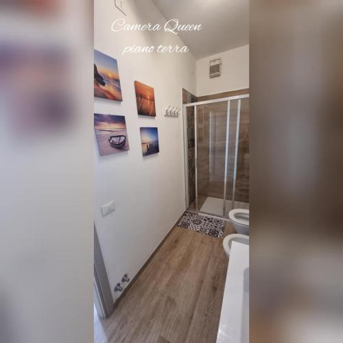 a bathroom with a shower and some pictures on the wall at B&B D'AMARE in Cupra Marittima