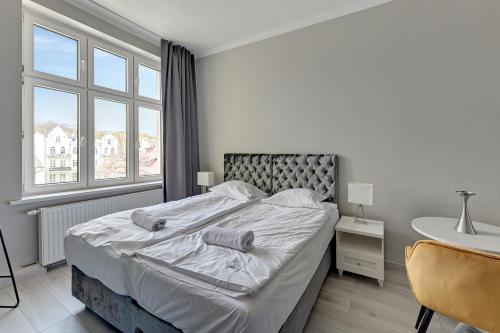 a bedroom with a large bed with a large window at La Casa del Grand Apartments Sopot in Sopot