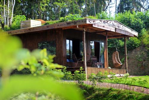 a wooden cabin with a deck in a garden at Cabana em meio a natureza com piscina. in Rodeio