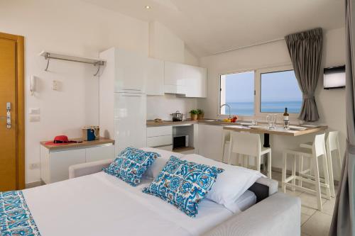 una camera con letto e una cucina con vista sull'oceano di Rubino Apartments a 100metri dal mare a Riccione