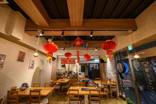 a restaurant with wooden tables and red lanterns at HOTEL STATE TENNOJI in Osaka