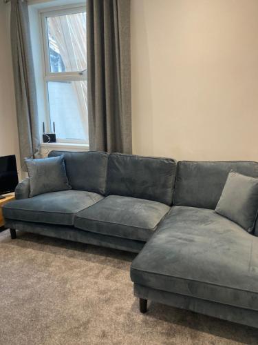 a gray couch in a living room with a window at Halfway House in Goole