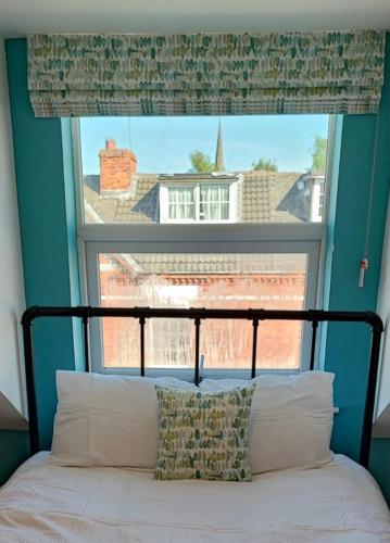 a bed in a room with a large window at Halfway House in Goole