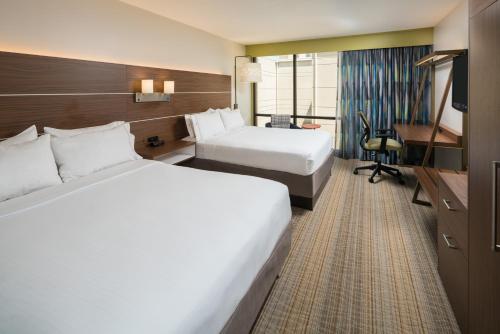 una camera d'albergo con due letti e una scrivania di Holiday Inn Express & Suites Springfield by IHG a Springfield