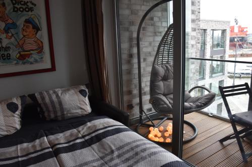 a living room with a bed and a chair and a window at NewPort Weser, NewPort Marina in Bremerhaven