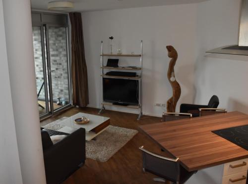 a living room with a dining room table and a television at NewPort Weser, NewPort Marina in Bremerhaven