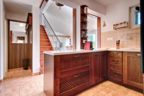 a kitchen with wooden cabinets and a staircase at Villa Anja in Pražnice
