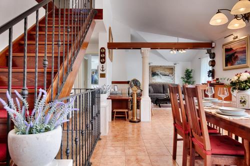 a dining room and living room with a spiral staircase at Villa Anja in Pražnice