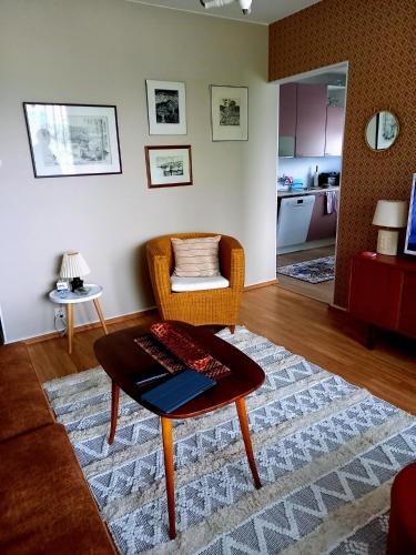 a living room with a coffee table and a chair at Citykoti in Varkaus