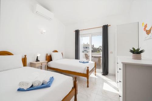 um quarto com duas camas e uma janela em Villa Harpista - Private pool and bbq em Albufeira