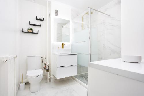 biała łazienka z toaletą i umywalką w obiekcie LeCosyMelunais : Parking gratuit + Balcon aménagé w mieście Melun