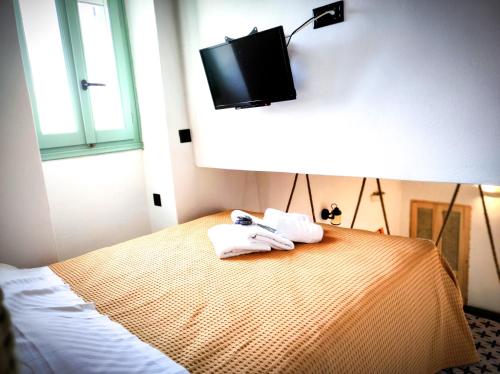 a bedroom with a bed with a tv on the wall at Mparmpa Nikoli in Skiros