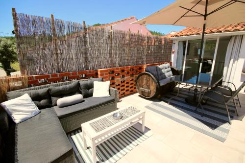 a patio with a couch and an umbrella at Casa Nórdica in Chão de Lamas