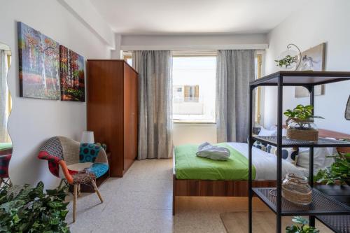 a bedroom with a bed and a chair in a room at Oasis - Cozy Studio in Larnaca in Larnaka