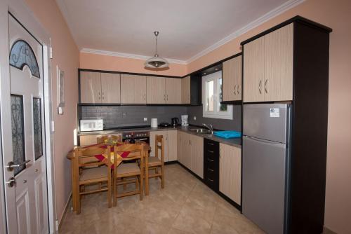 a small kitchen with a table and a refrigerator at Anna Apartments in Acharavi
