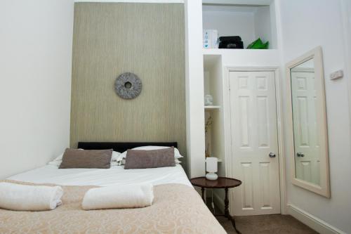 ein Schlafzimmer mit einem Bett und einer Uhr an der Wand in der Unterkunft Marine Parade Sea View - by Brighton Holiday Lets in Brighton & Hove
