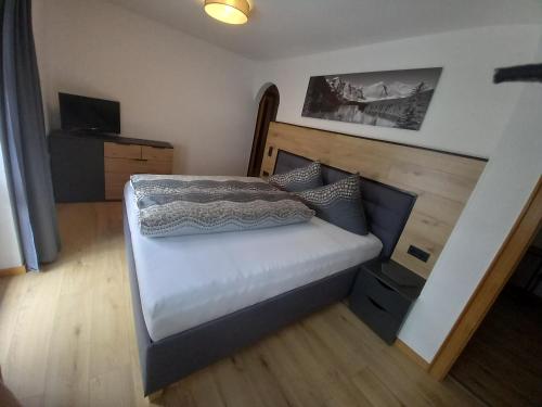 a bedroom with a bed with a wooden headboard at Haus Waldfriede in Sankt Leonhard im Pitztal