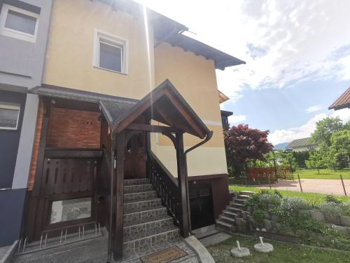 a house with a wooden door and stairs at Apartment LakeBled with Casle Bled view in Bled