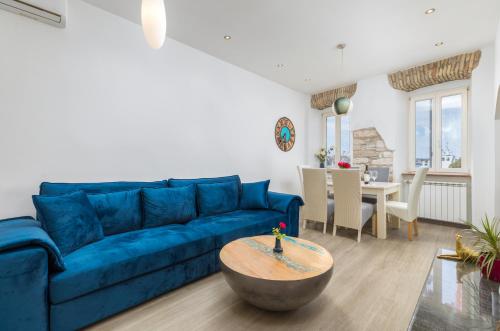 a living room with a blue couch and a table at Apartment Augusto - Sea view in Pula