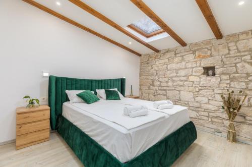 a bedroom with a large bed and a stone wall at Apartment Augusto - Sea view in Pula
