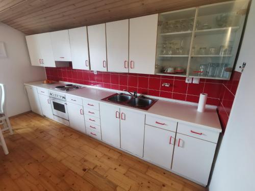 a kitchen with white cabinets and a sink at Apartment LakeBled with Casle Bled view in Bled