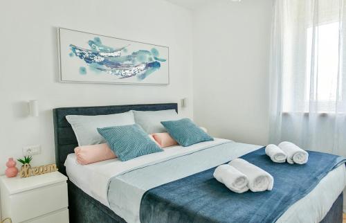 a bedroom with a large bed with towels on it at Apartment Aura in Poreč