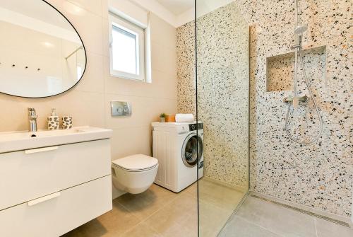 a bathroom with a washing machine and a shower at Apartment Aura in Poreč