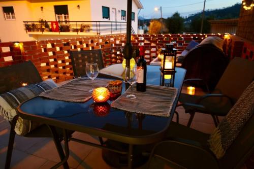 una mesa con botellas de vino y copas en el balcón en Casa Nórdica, en Chão de Lamas