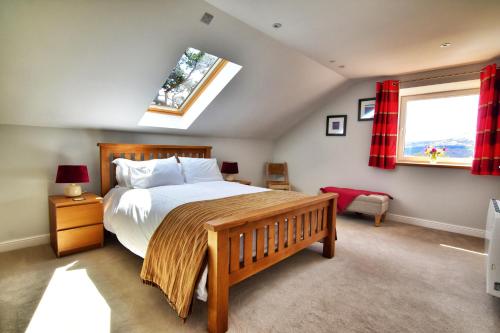a bedroom with a large bed and a skylight at Chic cottage near Elan Valley and Builth Wells in Llanwrthwl