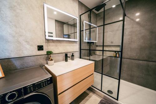 a bathroom with a sink and a washing machine at Luxury Apartment w. City Views in Košice Old Town in Košice