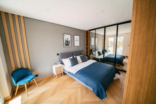 a bedroom with two beds and a blue chair at Luxury Apartment w. City Views in Košice Old Town in Košice