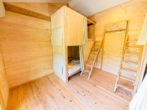 an empty room with wooden walls and bunk beds at Male Only Dormitory Guest House Amami Long Beach2 Vacation STAY 37987v in Amami