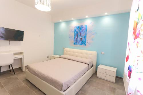 a bedroom with a bed and a desk and a tv at Il Violino degli Dei Holiday House in Agerola