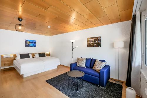 um quarto com uma cama e um sofá azul em Apartment next to Titlis Station em Engelberg