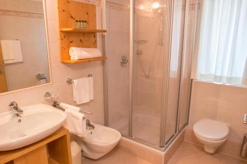 a bathroom with a shower and a sink and a toilet at Residence Rosarela in Badia