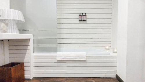 a white bathroom with a tub and a sink at Playa Luna Roja in Chapadmalal