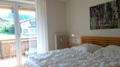 una camera con un letto e una grande finestra di FeWo Panorama270, Oberstaufen/Steibis a Oberstaufen