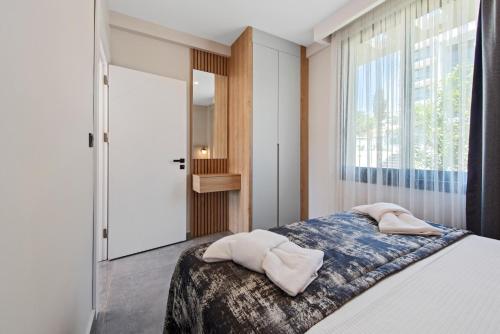 a bedroom with a bed and a large window at KADAGAN SUİTES AYASARANDA in Cesme