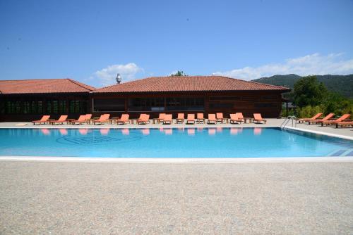 a large swimming pool with chairs and a building at Enso Inn in Fethiye