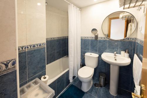 a bathroom with a toilet and a sink and a mirror at Apartamento La Merced. in Guadalajara