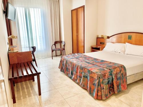 a hotel room with a bed and a chair at Hotel Arumí in Santa Eugenia de Berga