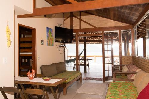 ein Wohnzimmer mit einem Sofa und einem Tisch in der Unterkunft Trindade Hospeda -Casa 1- Você a Varanda e o Mar in Trindade