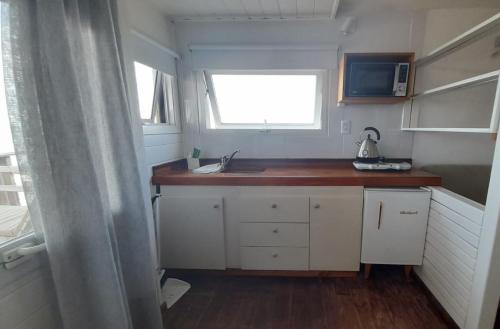 a small kitchen with a sink and a microwave at Playa Luna Roja in Chapadmalal