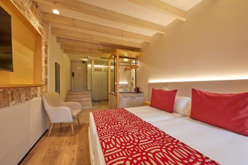 a bedroom with a large bed with red pillows at Fil Suites in Palma de Mallorca