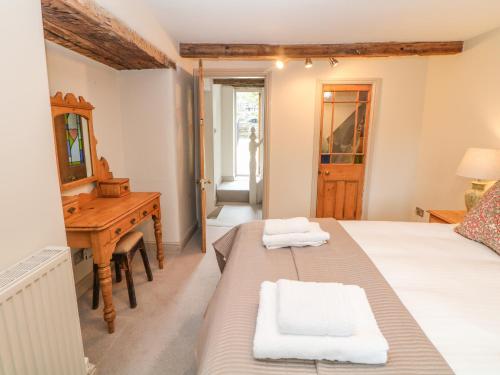 a bedroom with a bed and a desk and a mirror at Billy Whiskey's in Tideswell