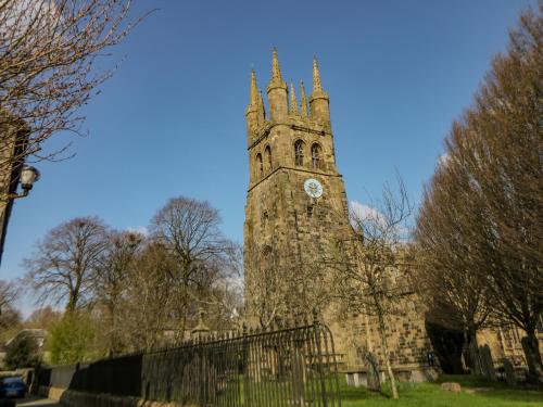 a building with a tower with a clock on it at Billy Whiskey's in Tideswell